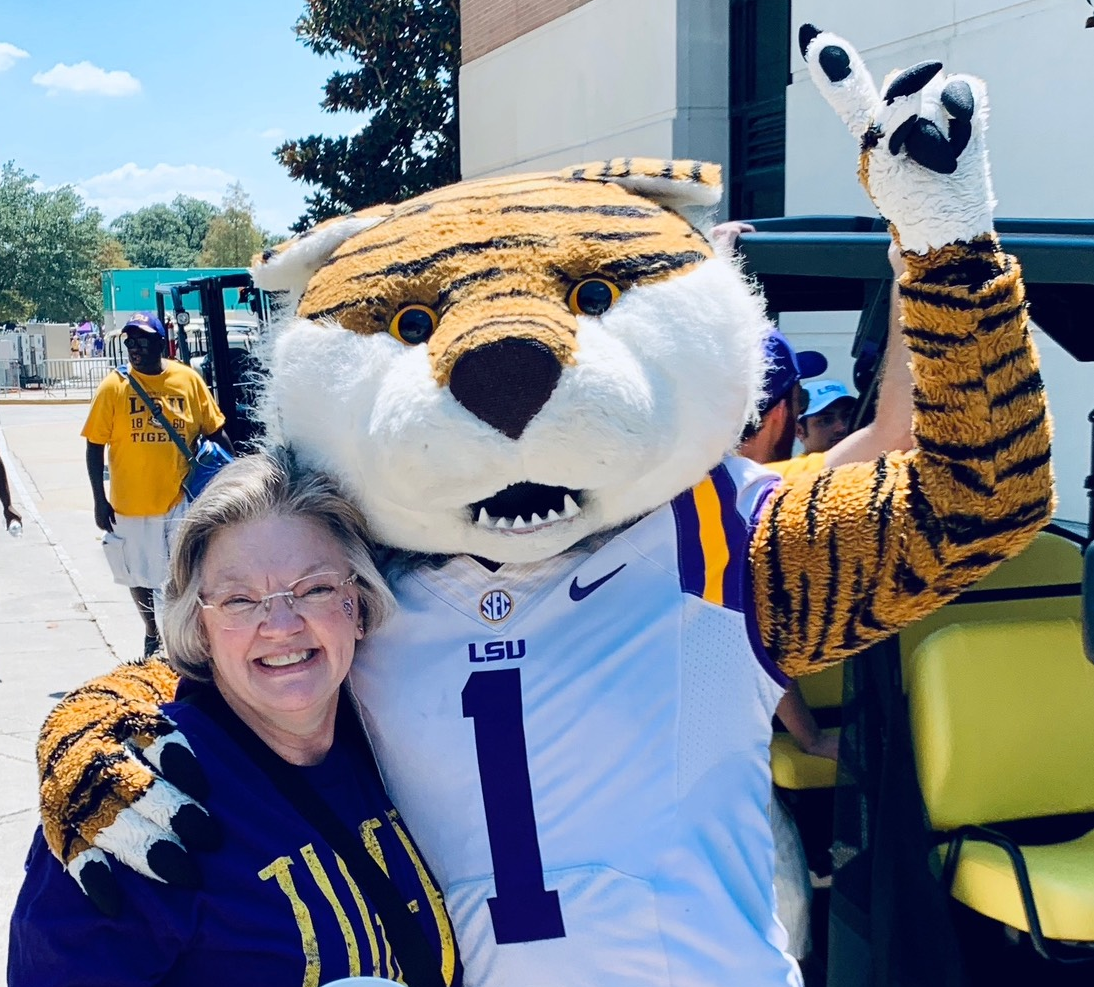 A woman posing with LSU Mike the Tiger mascot, Geaux Tigers