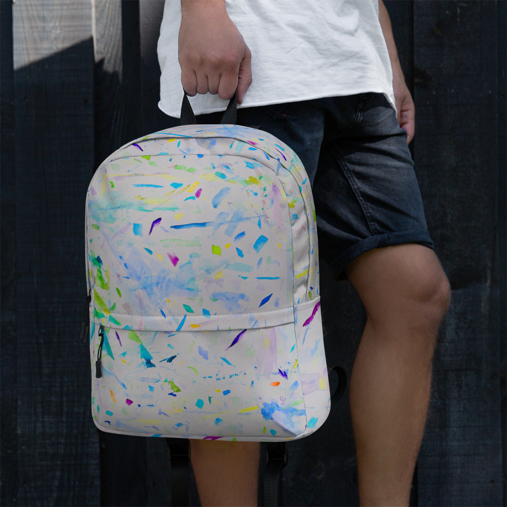 Person holding a colorful backpack with a black background