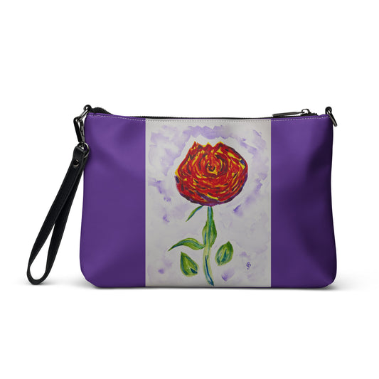 Purple clutch with a red flower design on a white background
