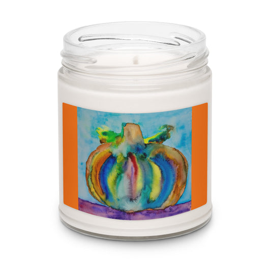 Candle in a jar with a colorful pumpkin design on the label against a white background