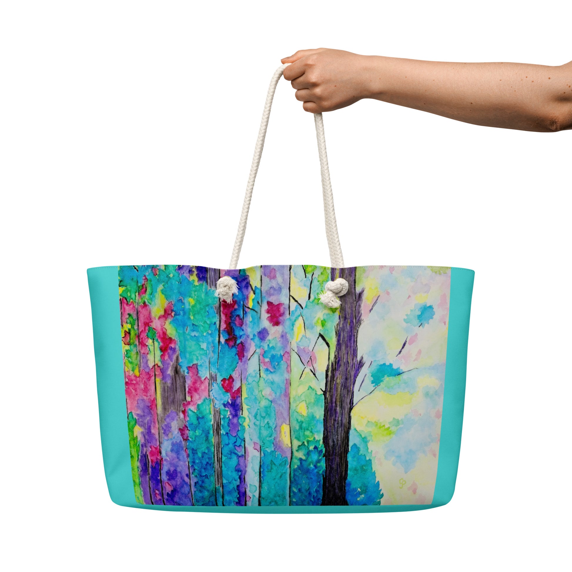 Tote bag with a colorful forest design held by a hand on a white background