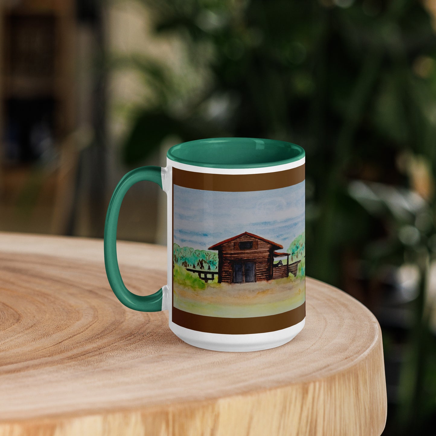 Mug with a watercolor barn design on a wooden surface