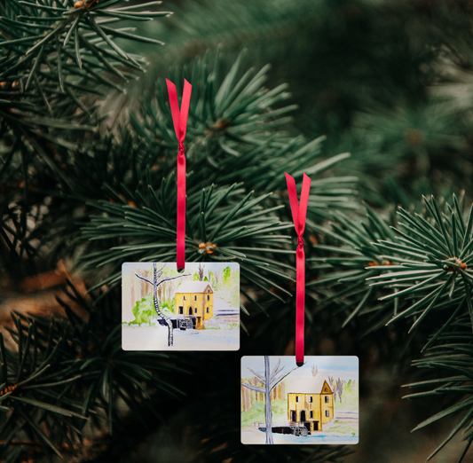 Two Christmas ornaments on a pine branch.