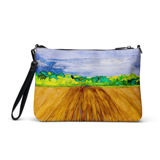 Purse with a landscape design featuring a field and sky.