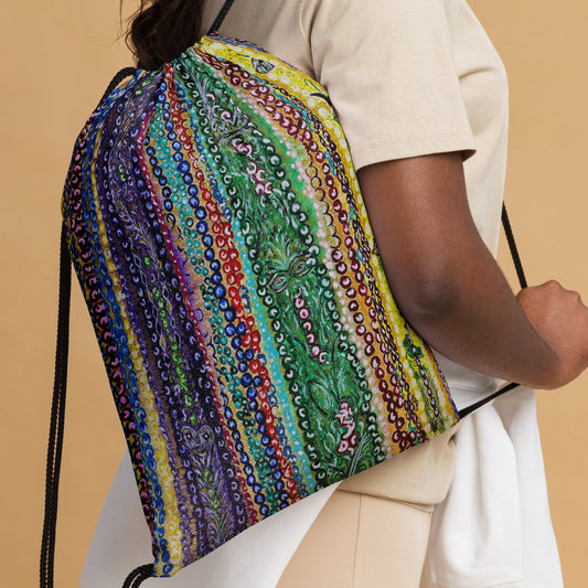 Person holding a colorful drawstring bag with intricate patterns on a beige background