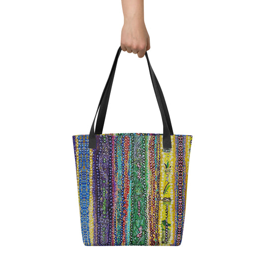 Colorful striped tote bag held by a hand on a white background