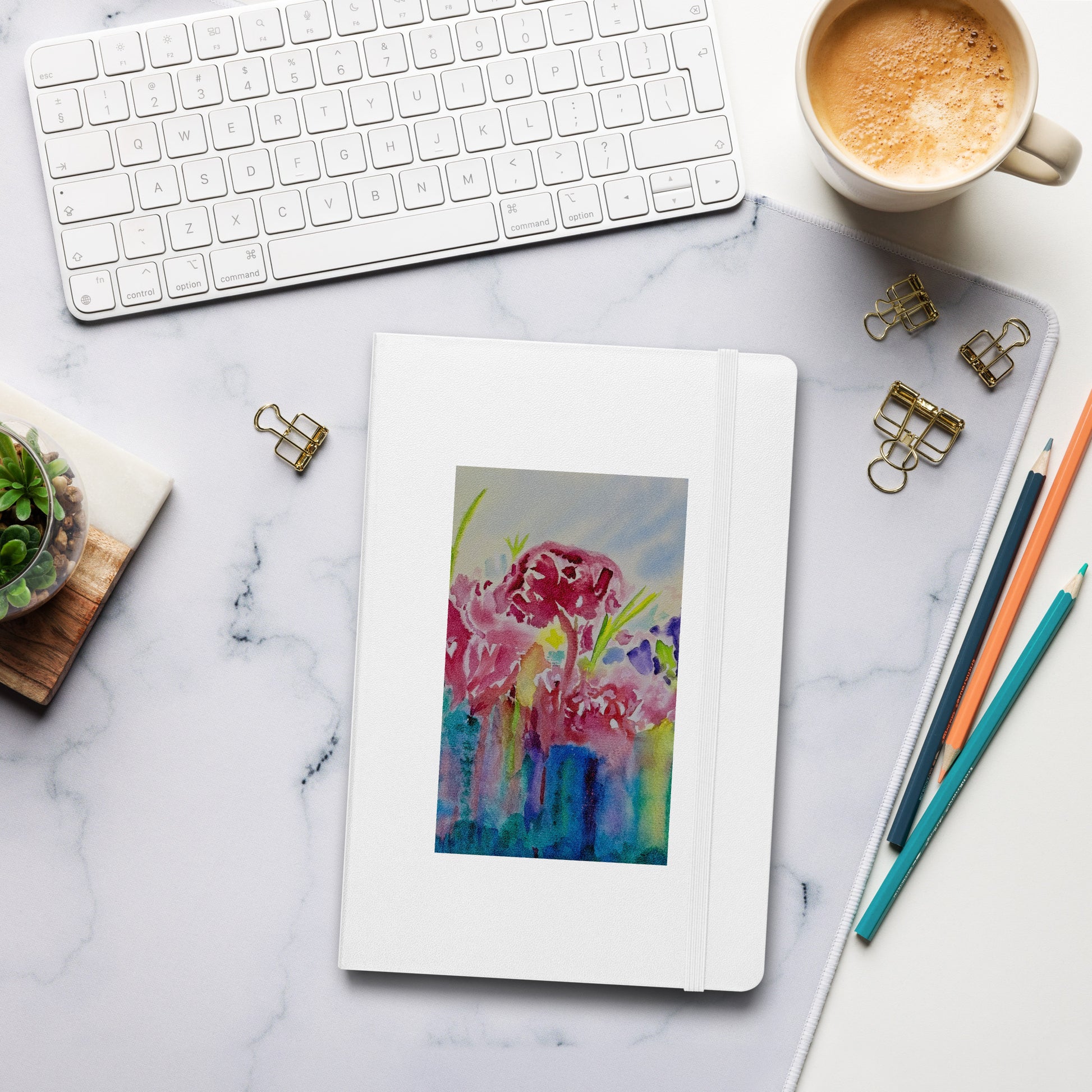 Colorful floral notebook on a tablet with office supplies on a marble desk