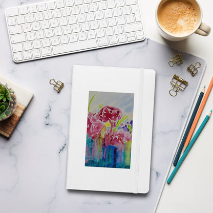 Colorful floral notebook on a tablet with office supplies on a marble desk