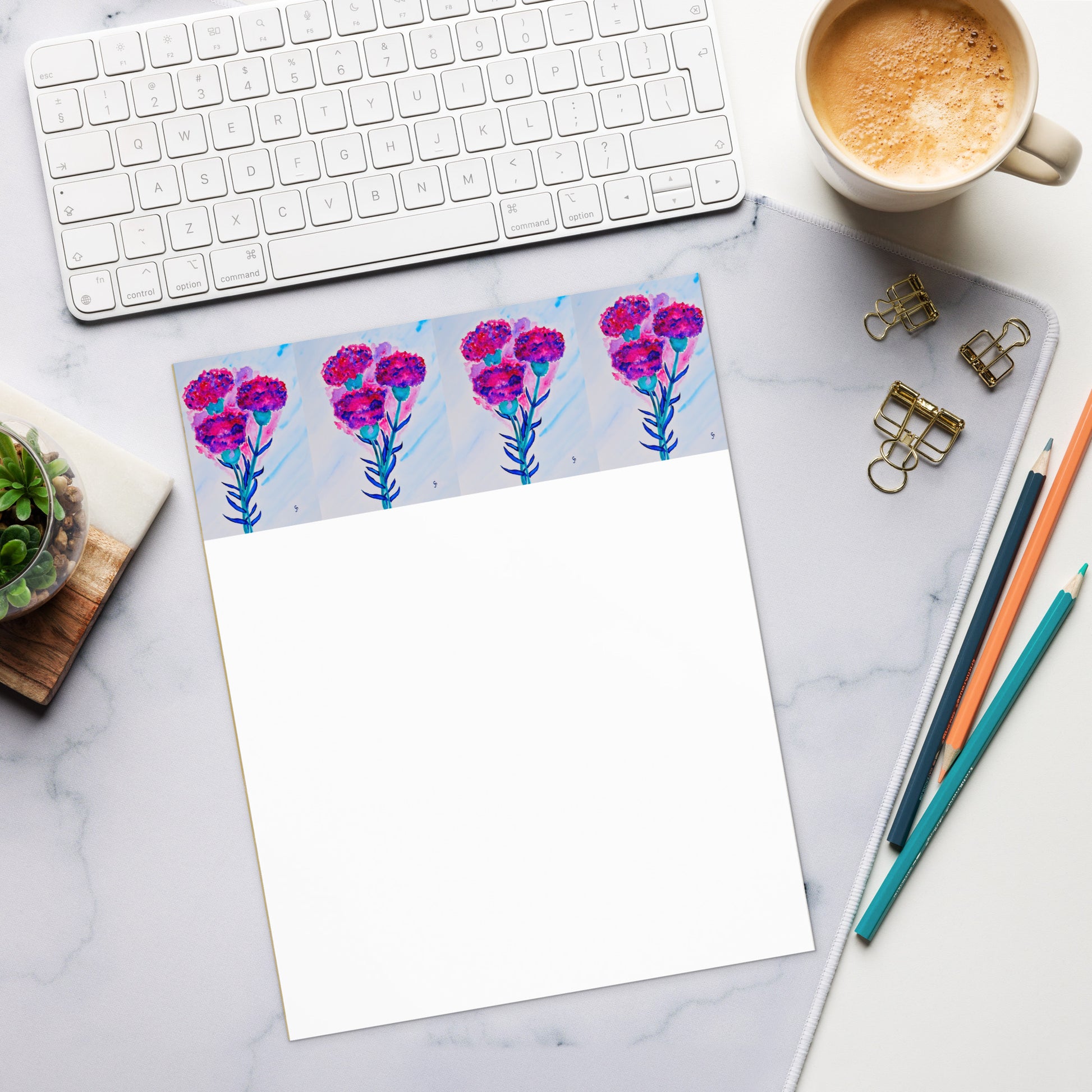 Floral notepad on a marble desk with office supplies