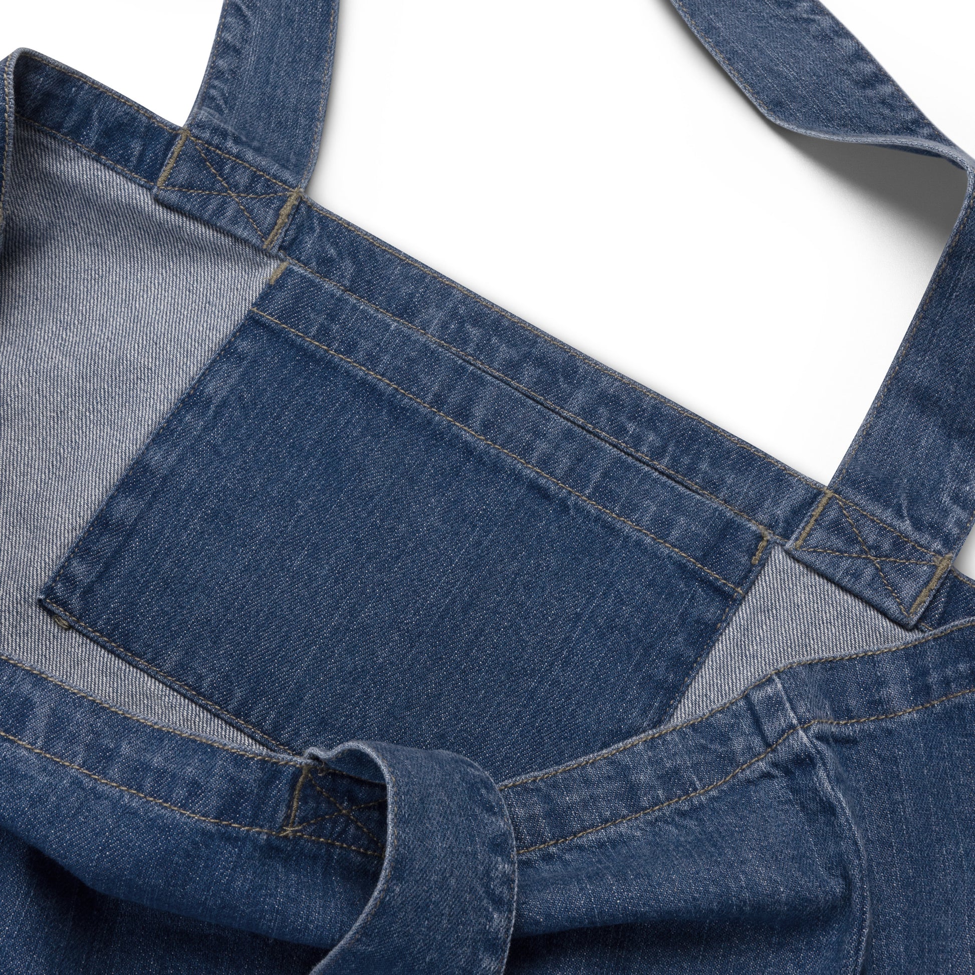 Close-up of a blue denim tote bag inside pocket on a white background