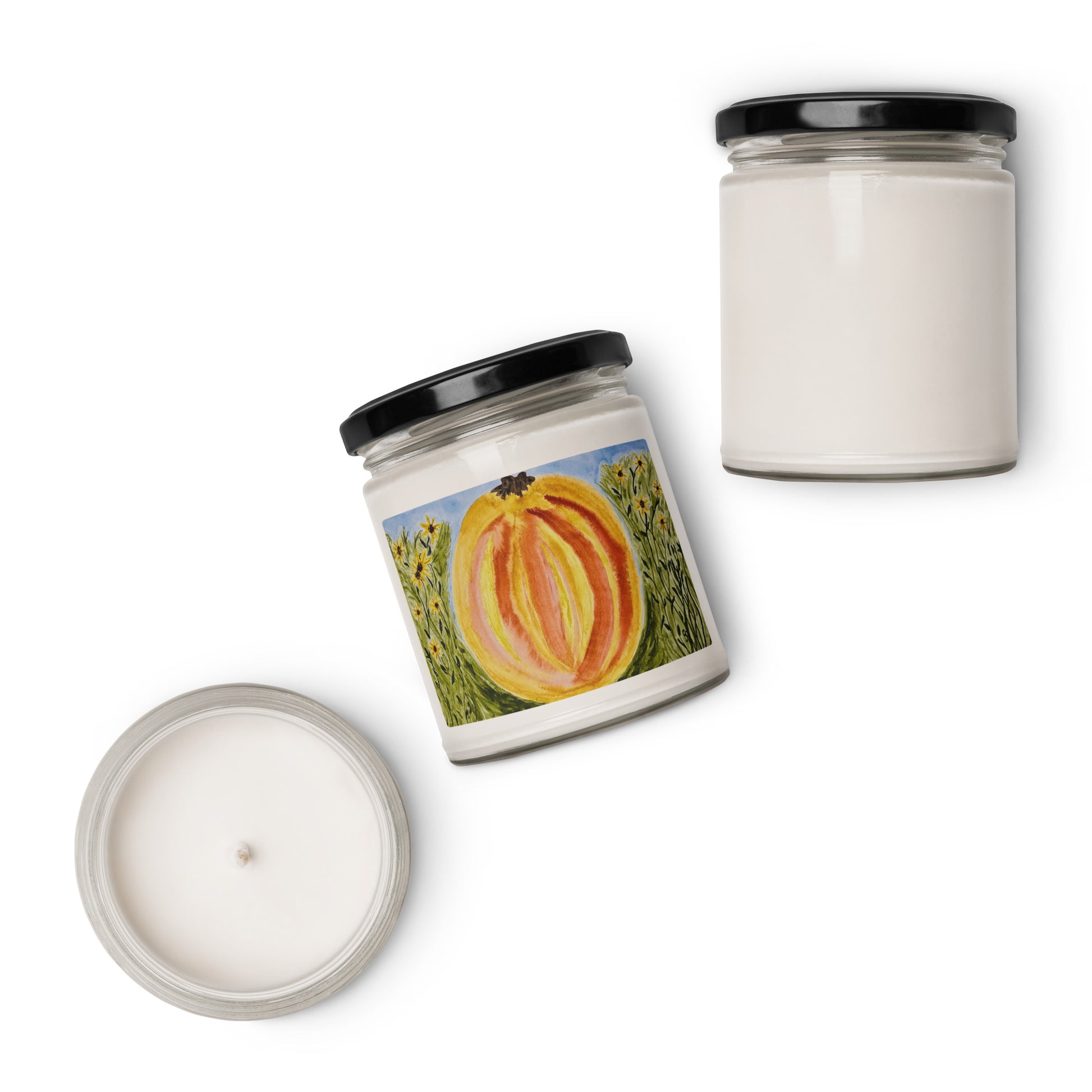 Two candles on a white background, one with a pumpkin design on the label.