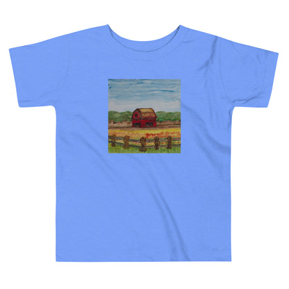 Blue t-shirt with a small square print of a red barn on a white background