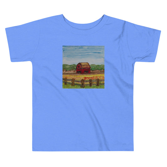 Blue t-shirt with a small square print of a red barn on a white background