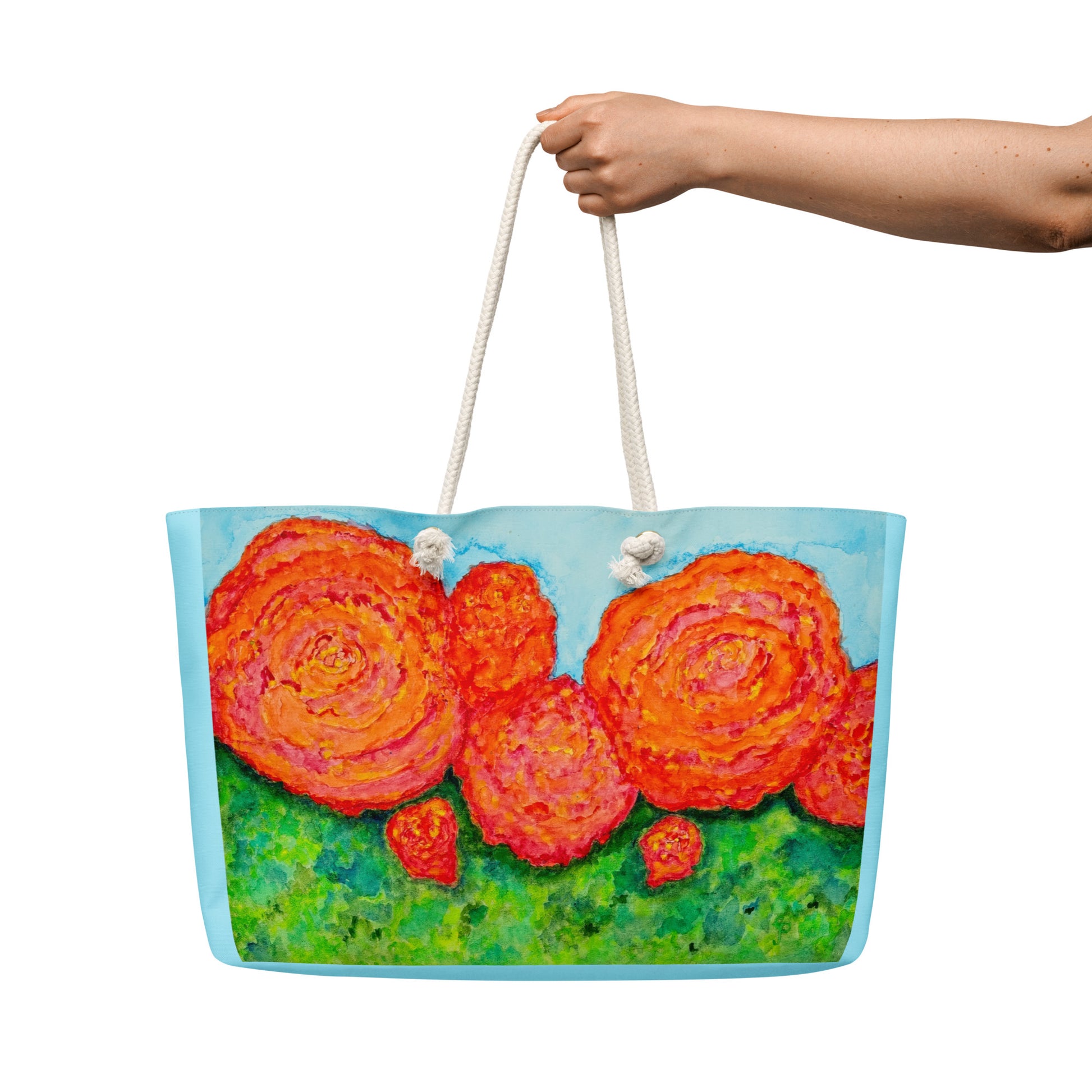 Tote bag with floral design held by a hand on a white background