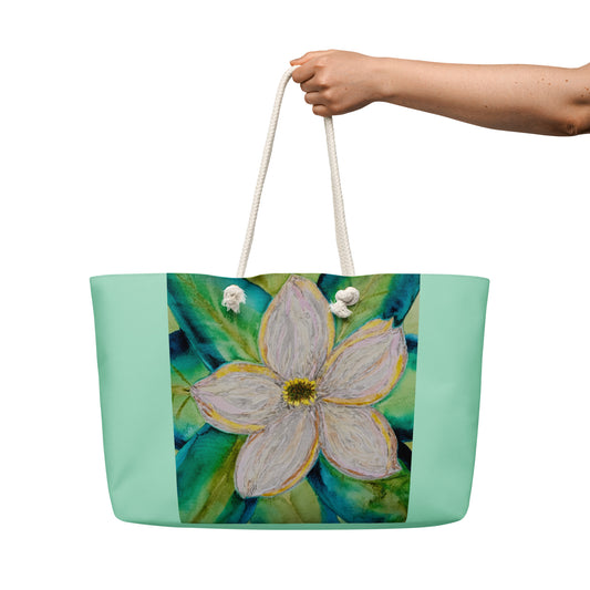 Oversized tote bag with a beautiful floral magnolia design held by its durable white rope handles