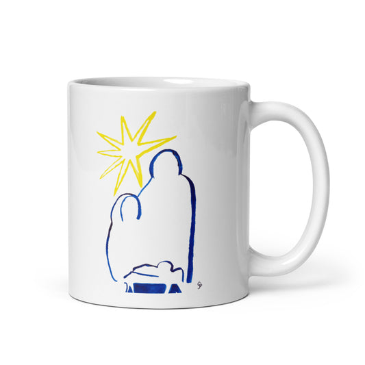 White mug with blue and yellow nativity scene design on a white background for the Christmas or holiday season