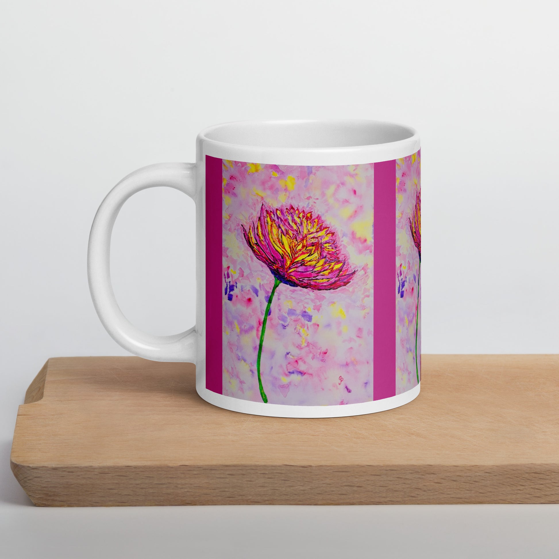 White mug with a pink floral design on a wooden surface