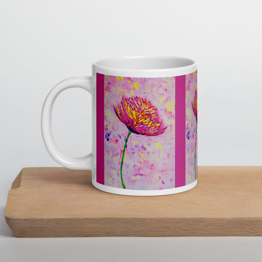 White mug with a pink floral design on a wooden surface