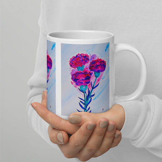 Hand holding a mug with a colorful floral design on a plain background